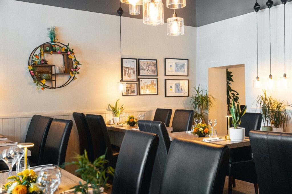 The dining room of the restaurant L’Orangerie in Montargis, tables laid out and warm lighting, available for private events